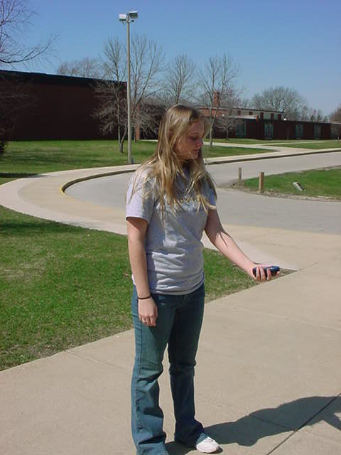 Student holding a GPS unit in the field